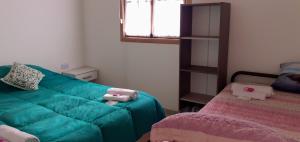 a living room with a green couch and a bed at Cabaña La Escondida in Trelew