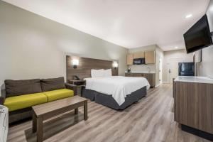 Habitación de hotel con cama y sofá en SureStay Studio by Best Western Conroe Downtown, en Conroe