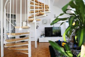 a living room with a staircase and a tv at Modern luxury duplex in Düsseldorf-Benrath in Düsseldorf