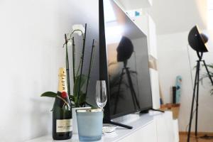 einen Tisch mit einer Flasche Wein und einen TV in der Unterkunft Modern luxury duplex in Düsseldorf-Benrath in Düsseldorf