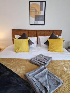 1 cama con 2 almohadas y toallas en Cosy 3 Bedroom House in Beeston, Leeds, LS11 7JP, en Beeston