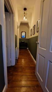 a hallway with a door and a television in a room at Central Jesmond 3BD Apt, Parking, Nr Newcastle in Jesmond