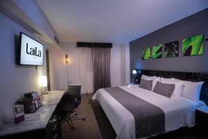 a hotel room with a bed and a desk and a television at LaiLa Hotel Mexico City Reforma in Mexico City