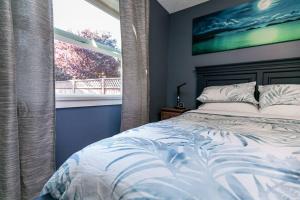 een slaapkamer met een bed en een groot raam bij Great 1-bedroom Suite Near Downtown Langford in Victoria
