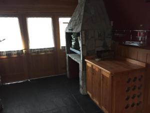 eine Küche mit einem Steinkamin in einem Zimmer mit Fenstern in der Unterkunft Casa Las Rosas in San Carlos de Bariloche