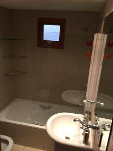 y baño con lavabo y bañera con ventana. en Casa Las Rosas, en San Carlos de Bariloche