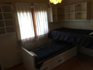 Un dormitorio con dos literas y una ventana. en Casa Las Rosas, en San Carlos de Bariloche