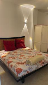 ein Schlafzimmer mit einem großen Bett mit roten Kissen in der Unterkunft Red Ruby Compound منتجع الياقوتة الحمراء in Hurghada