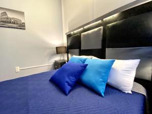 a bed with two blue and white pillows on it at ROOMIES HOSTEL Cibeles in Mexico City