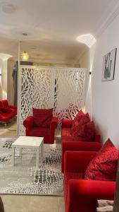ein Wohnzimmer mit zwei roten Sofas und einem Tisch in der Unterkunft Red Ruby Compound منتجع الياقوتة الحمراء in Hurghada