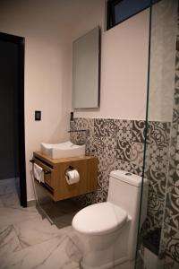 a bathroom with a toilet and a sink and a mirror at HOTEL BOUTIQUE MONARCA in El Paraíso