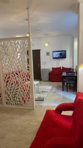 ein Wohnzimmer mit einem roten Sofa und einem TV in der Unterkunft Red Ruby Compound منتجع الياقوتة الحمراء in Hurghada