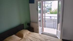 a bedroom with a bed and a large window at Cassiopée avec jardin in Fleury-les-Aubrais