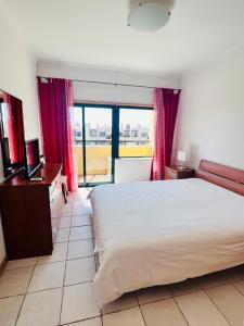 ein Schlafzimmer mit Bett, Schreibtisch und Fenster in der Unterkunft Apartamento golf-mar in Vilamoura
