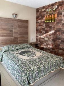 een slaapkamer met een bed en een bakstenen muur bij Hotel D´ Alba in Río Blanco