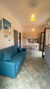 een woonkamer met een blauwe bank en een keuken bij BEACH HOUSE STEFI in Golfo Aranci