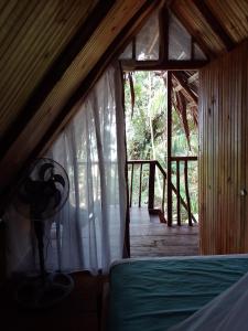 a bedroom with a bed in a room with a window at Cabañas Mangle House in Buenaventura