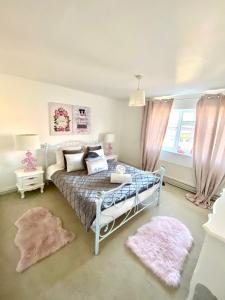 a bedroom with a bed and two rugs at Farmhouse Retreat with Hot Tub, Pool, Horses, Games Room, Free Car Park, Only 45 min from Oxford Circus in Stapleford Tawney +81 photos