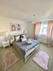a bedroom with a bed and two rugs at The Farm Rooms in Stapleford Tawney