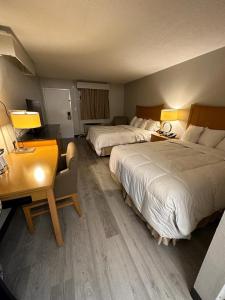 Pokój hotelowy z 2 łóżkami i biurkiem w obiekcie Lanett Inn w mieście Lanett