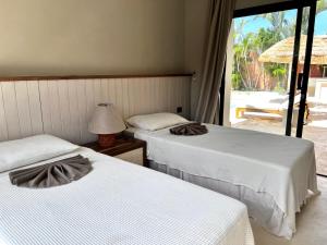 2 Betten in einem Zimmer mit Fenster in der Unterkunft Kaikai Beach House, un lujo en el Caribe in Las Terrenas + 27 Fotos