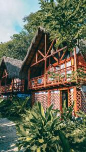 Casa de madera grande con techo de paja en Bio Rio Hotel en San Jerónimo