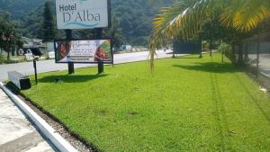 een bord in het gras naast een straat bij Hotel D´ Alba in Río Blanco