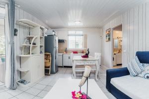 a living room with a blue couch and a kitchen at Lagoon Dream in Moorea