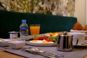 a breakfast table with a plate of food and orange juice at HOTEL HIBA in Nouakchott