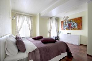 a bedroom with a bed and a painting on the wall at Peter the Great Apartments on Nevsky in Saint Petersburg