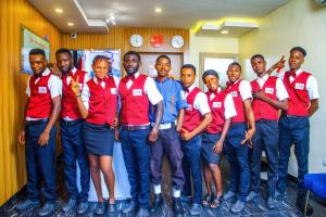 a group of men in red shirts posing for a picture at ONTARIO SUITES in Lagos