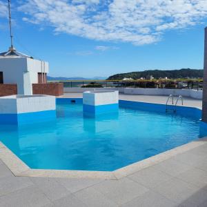 a swimming pool on the roof of a building at Ape frente praia Ponta das Canas/3min Canasvieiras in Florianópolis