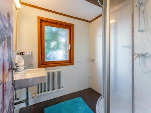 een badkamer met een douche, een wastafel en een raam bij Chalet H XL in Königsleiten
