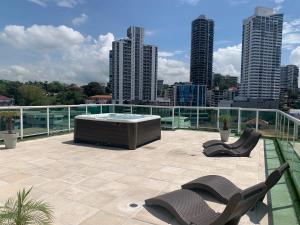 een patio met een hot tub en stoelen op een dak bij 5A - Boutique Apartment ! High end furnished! 4BR in Panama-Stad