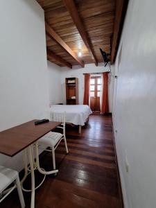 a room with two beds and a table and chairs at Casa Wayra Cajamarca in Cajamarca