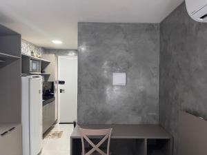 a small kitchen with a table and a gray wall at Flat Comfort Vista Mare Studios - Intermares in Cabedelo