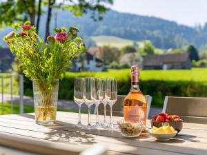 una botella de vino y tres copas de vino en una mesa en Goldstern, en Sankt Lorenzen ob Murau