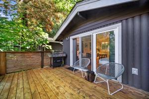 a deck with two chairs and a grill on it at Sunwolf Riverside Cabins in Brackendale