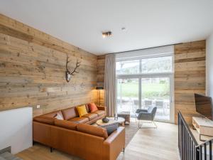 a living room with a wooden wall at Aquarius Haus 8 TOP 17 in Sankt Lorenzen ob Murau