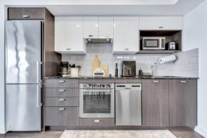 a kitchen with a stainless steel refrigerator and appliances at Views & Comfort: Your Perfect Long Stay Condo in Toronto