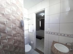 Baño blanco con lavabo y aseo en Residencial André Reis, en Fortaleza