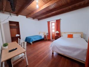 a bedroom with a bed and a table and a desk at Casa Wayra Cajamarca in Cajamarca
