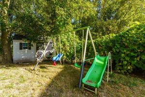 um parque infantil num quintal com um baloiço em Fun & Cozy Retreat: Nature & Games em Trenton