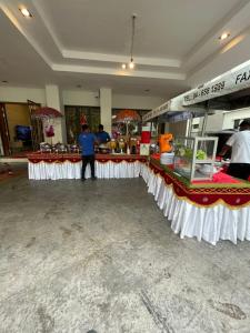 Een man voor een toonbank in een winkel. bij 30PAX 7BR Villa with Kids Swimming pool, KTV, Pool Table n BBQ near SPICE Arena Penang 9800 SQFT in Bayan Lepas