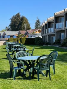 eine Reihe von Tischen und Stühlen im Gras in der Unterkunft Shorewater Resort in Qualicum Beach