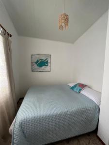 a bedroom with a bed in a white room at CASA ARENA en la Rambla, frente a la playa ,para 4 personas in Colonia del Sacramento