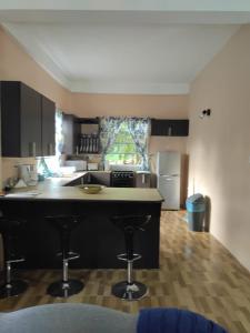 a kitchen with a counter and stools in it at The Ultimate Escape in Soufrière