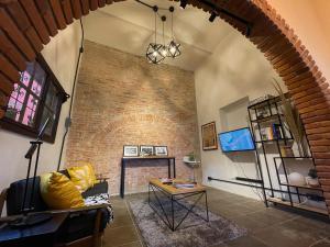 a living room with a couch and a brick wall at Hotel Casa Ibarra in Acámbaro