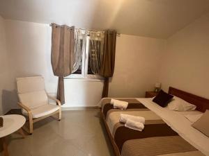 sypialnia z 2 łóżkami, krzesłem i oknem w obiekcie Apartments by the sea Sali, Dugi otok - 8110 w mieście Sali