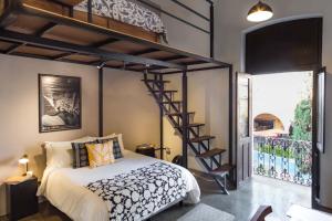 1 dormitorio con cama elevada y escalera de caracol en Casa Ibarra en Acámbaro